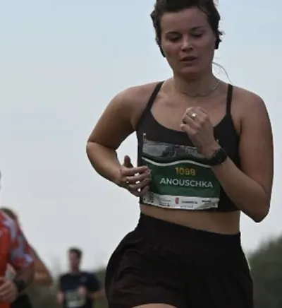 Hardloopster Anouschka met startnummer 1099 tijdens een wedstrijd, als resultaat van coaching bij FitCoach Wilma